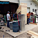 People worknig on a solar food dehydrator. outdoors.